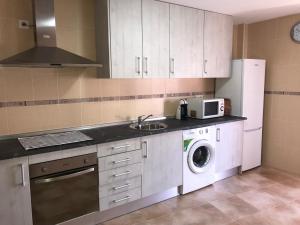 a kitchen with a sink and a washing machine at Lacasadeyolandayedu in Medina del Campo