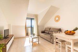 a living room with a couch and a table at Apartamentos Punta Lucero en Portonovo in Portonovo
