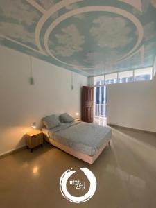 een slaapkamer met een bed met een schilderij aan het plafond bij RETE ZEN GUESTHOUSE in Pointe-à-Pitre