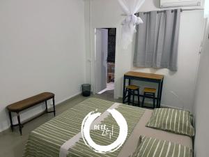 um quarto com uma cama, uma mesa e uma janela em RETE ZEN GUESTHOUSE em Pointe-à-Pitre