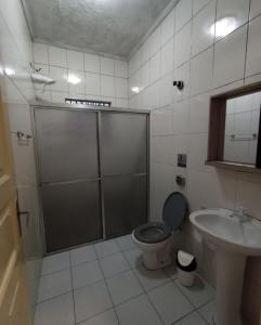 ein Badezimmer mit Dusche, Toilette und Waschbecken in der Unterkunft Casa do Ph in Praia Grande