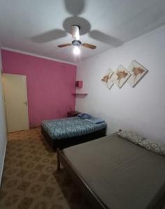 Zimmer mit 2 Betten und einem Deckenventilator in der Unterkunft Casa do Ph in Praia Grande