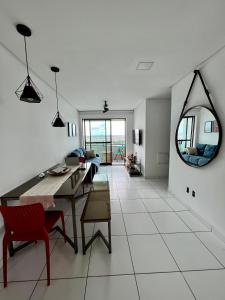 a dining room and living room with a table and chairs at Vale Hospedar Orla Apart in Petrolina