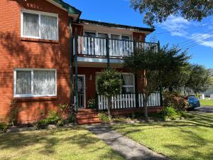 una casa de ladrillo rojo con balcón en Luxury 4 bedroom house, en Deewhy