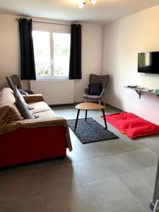 sala de estar con sofá rojo y TV en Les pierres de Lecq, en Portbail