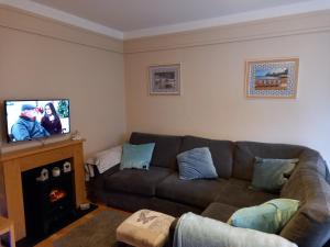 a living room with a couch and a flat screen tv at 24 New Esplanade Court in Paignton