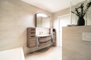 a bathroom with a sink and a mirror at Ferienwohnung Oba‘doba Falke in Pfronten +37 photos