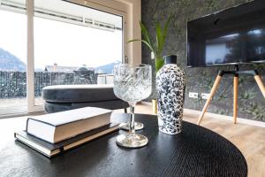 a table with a wine glass and books and a vase at Ferienwohnung Oba‘doba Falke in Pfronten