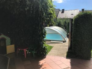 a swimming pool in a yard next to a hedge at Ubytování Duškovi in Lipno nad Vltavou