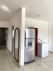 a kitchen with a white refrigerator in a room at LOFT en el norte, ideal para estudiantes y familia in Aguascalientes