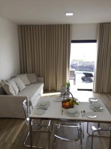 un soggiorno con un tavolo e un divano di Calheta Ocean View Apartments 1 - Air Condition a Estreito da Calheta
