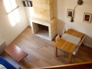 ein Wohnzimmer mit einem Tisch und einem Kamin in der Unterkunft Appartement Saint Emilion in Saint-Émilion