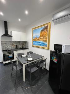 een keuken met een tafel en stoelen en een koelkast bij Case vacanze donna Ina in Palermo