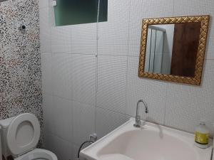 a bathroom with a sink and a toilet and a mirror at Apartamento 2 Bairro Boa Vista 1 in Caruaru