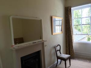 a living room with a fireplace with a large mirror at Swinton Manse & Gardens in Swinton