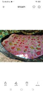 un letto con una coperta rosa con fiori sopra di พักดีโฮม วิวหมอก เขาค้อ a Khao Kho