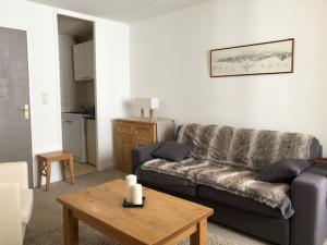 - un salon avec un canapé et une table dans l'établissement Vue panoramique - 4pers - parking, à La Mongie