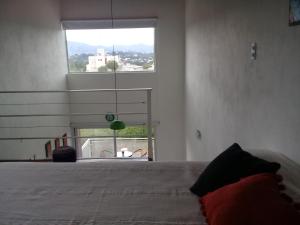 1 dormitorio con cama y ventana grande en Dúplex La Delfina 2 en Villa Carlos Paz