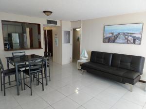 a living room with a black couch and a table at Coral Beach Isla Verde Beach Front Large 1 Bedroom Apt 208 Tower 1 in San Juan