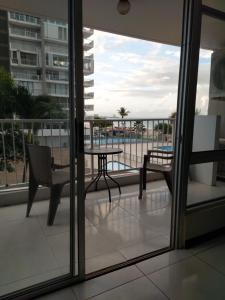 a balcony with a table and chairs and a view of the ocean at Coral Beach Isla Verde Beach Front Large 1 Bedroom Apt 208 Tower 1 in San Juan