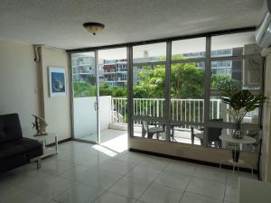 a living room with a view of a balcony at Coral Beach Isla Verde Beach Front Large 1 Bedroom Apt 208 Tower 1 in San Juan