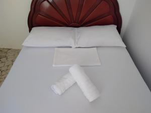 a bed with two rolls of toilet paper on it at Vi&Li Suites in Aracaju