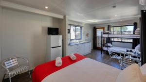 una camera con letto con coperta rossa e cucina di Emerald Tourist Park a Emerald