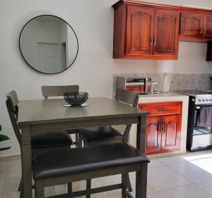 a kitchen with a table with chairs and a mirror at Linda, cerca de todo, parqueo, patio, netflix in La Ceiba