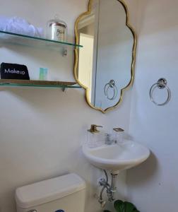 La salle de bains est pourvue d'un miroir, d'un lavabo et de toilettes. dans l'établissement Linda, cerca de todo, parqueo, patio, netflix, à La Ceiba