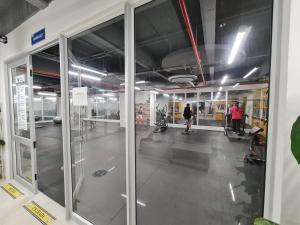 a gym with glass doors and people in a room at Confortable apartamento en conjunto Puerto Azul Club House in Ricaurte