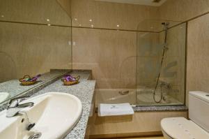 uma casa de banho com um lavatório, um chuveiro e um WC. em Motel Cancun León em Ardón
