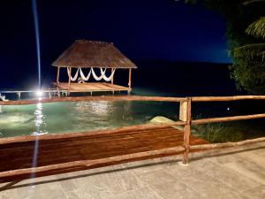 a swimming pool with a gazebo in the water at night at Casa La Joya Bacalar in Bacalar