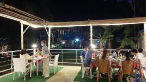 people sitting at tables with umbrellas at Holiday Resort - SHA Plus in Ko Yao Noi