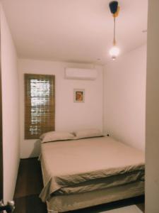 1 dormitorio con 2 camas y ventana en El Barco, en Punta del Este