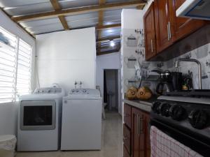 eine Küche mit einem Herd, einer Waschmaschine und einem Trockner in der Unterkunft Cozy Studios-Private Entrance- HS Internet-AC-Hot Water-Backup Generator-near the Beach in San Felipe de Puerto Plata