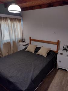 a bedroom with a large bed with a black blanket at Casa de montaña Manantiales-Nazareth in Potrerillos