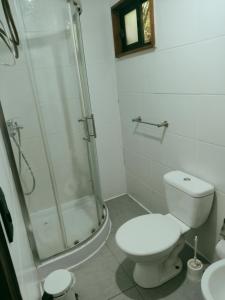 Un baño blanco con ducha y WC. en El Barco, en Punta del Este