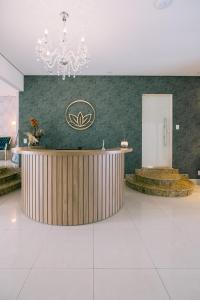 a lobby with a reception desk and a chandelier at Prosper Executive Hotel in Capivari