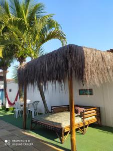 a hut with a bed and a straw roof at Hostel Praia Centro Itanhaém in Itanhaém +24 photos
