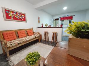 sala de estar con sofá y mesa en Chalé da Ana - Ilhabela, en Ilhabela