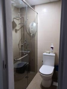 a bathroom with a toilet and a glass shower at Era Amazing Manhattan Suite in Penampang
