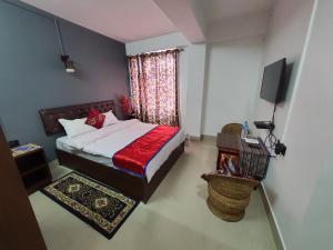 a bedroom with a bed and a television in it at Chunni homestay in Gangtok +1 photo