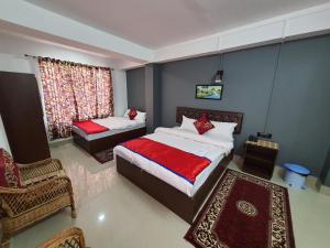 a bedroom with two beds and a chair and a window at Chunni homestay in Gangtok