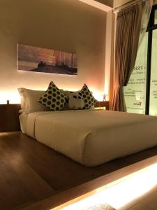 Un dormitorio con una cama grande con almohadas. en Yellow door Hua Hin, en Hua Hin