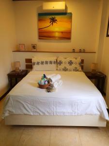 een slaapkamer met een wit bed en een mand met handdoeken bij Greenyard Inn in Boracay