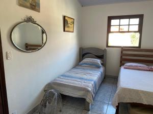 1 dormitorio con 2 camas individuales y espejo en Casa aconchegante - Búzios, en Búzios