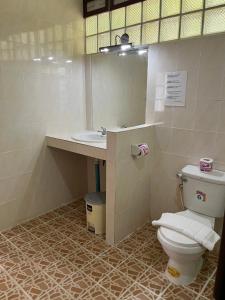 a bathroom with a toilet and a sink and a mirror at Plaa's Thansadet Resort in Than Sadet Beach