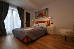 a bedroom with a bed and a large window at R&B Apartments in Predeal