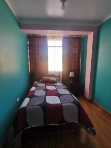 1 dormitorio con 1 cama en una habitación con ventana en Apartamento Hogareño con 3 dormitorios en Huancayo