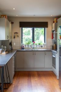 a kitchen with white cabinets and a window at The Loft at Sixty-7 in Queenstown